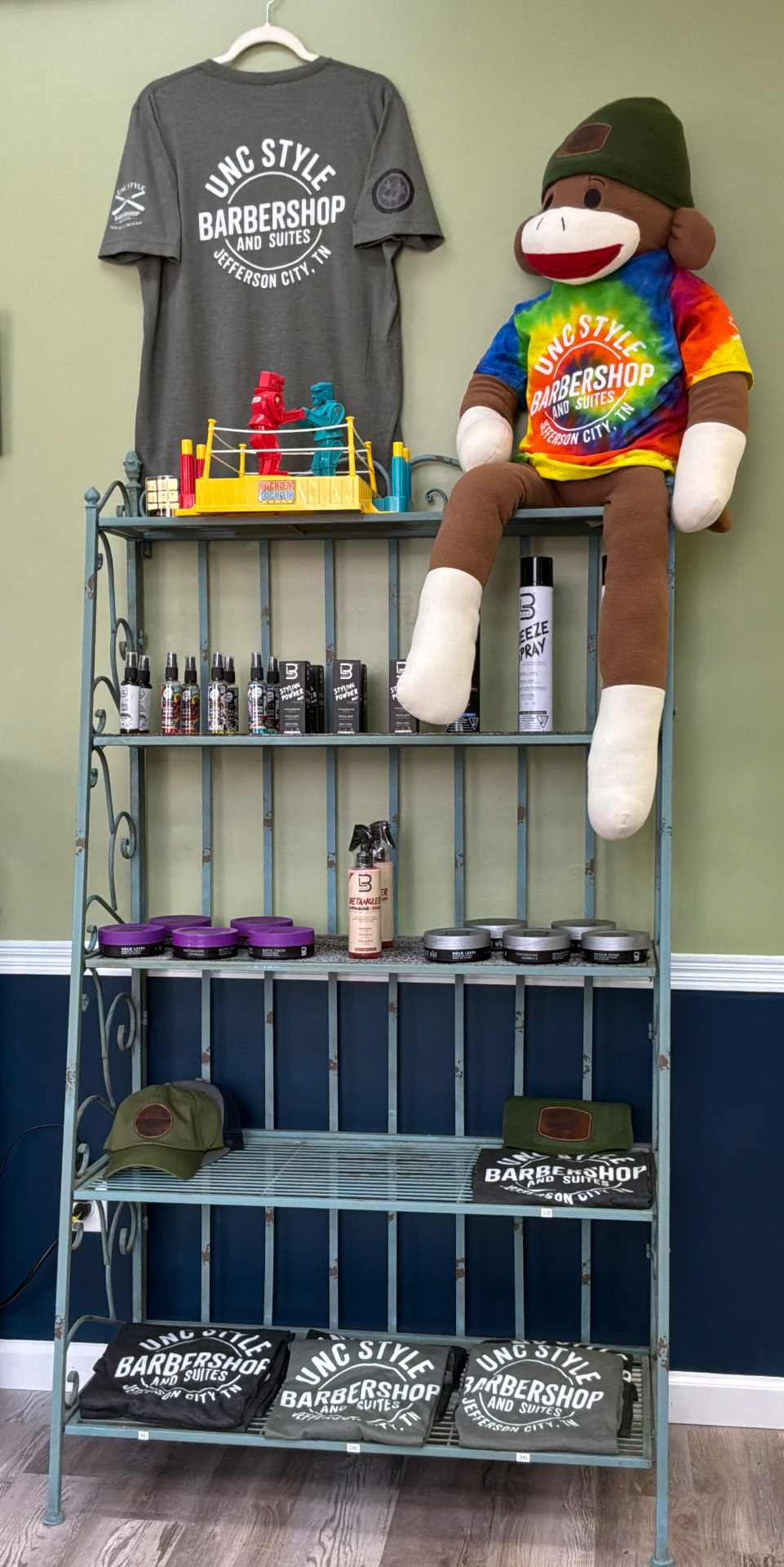 Product shelf with pomades, sprays, and waxes at Unc Style Barbershop and Suites