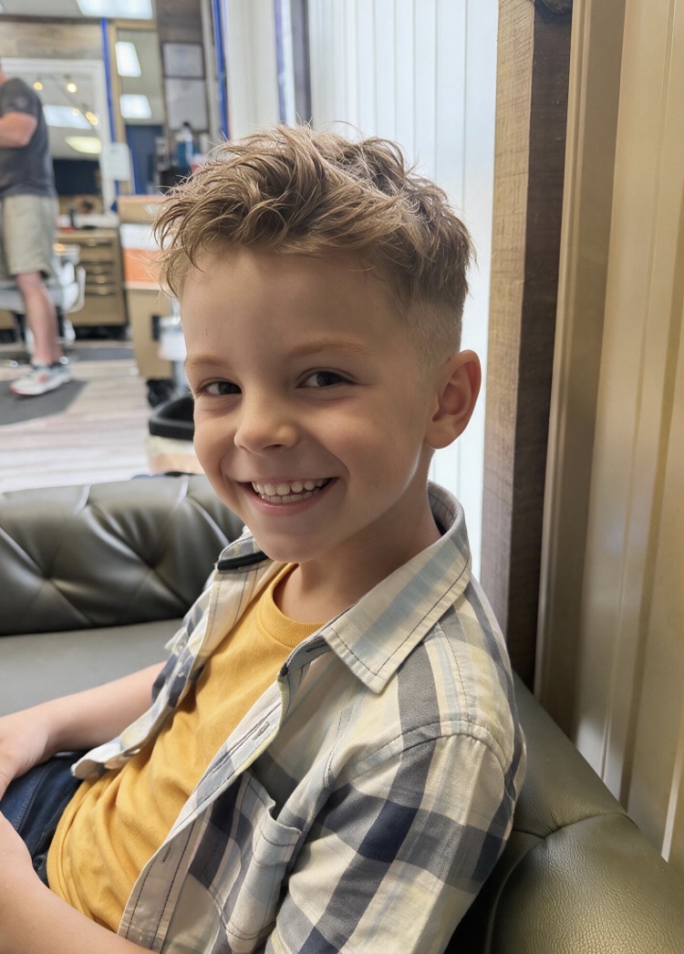 Smiling boy in the barber chair after his haircut